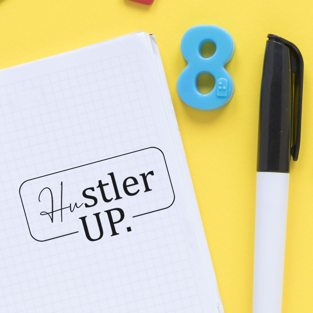 Motivational rubber stamp reading Hustler Up on notebook, ideal for custom planner and journal stamping.