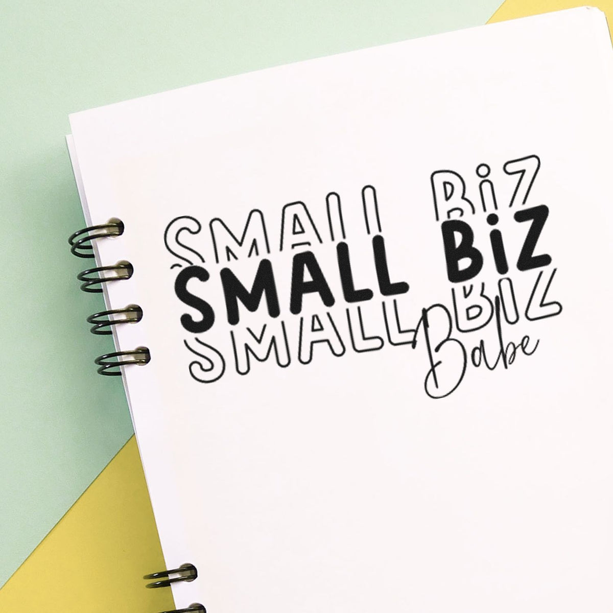 Small business rubber stamp design with bold SMALL BIZ and Small Business Babe text on notebook paper.