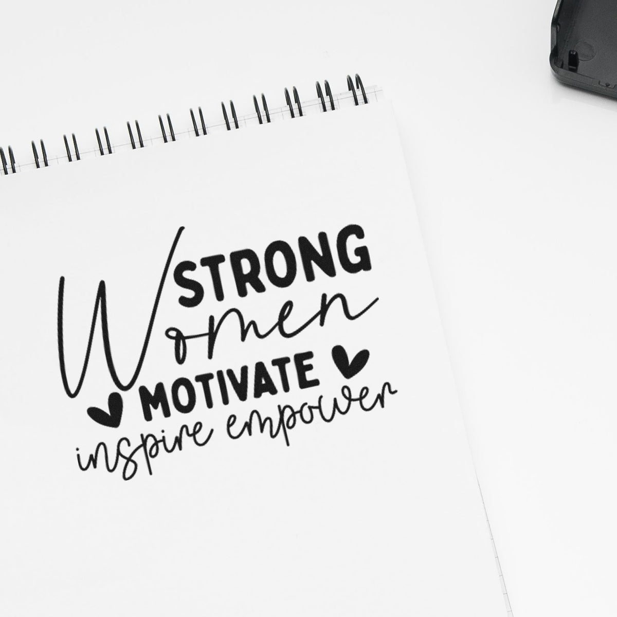 Strong Women Motivate Inspire Empower PSI Pre-Inked Stamp imprint stamped in black ink. The words "Strong women motivate inspire empower" appear in mixed lettering with hearts.