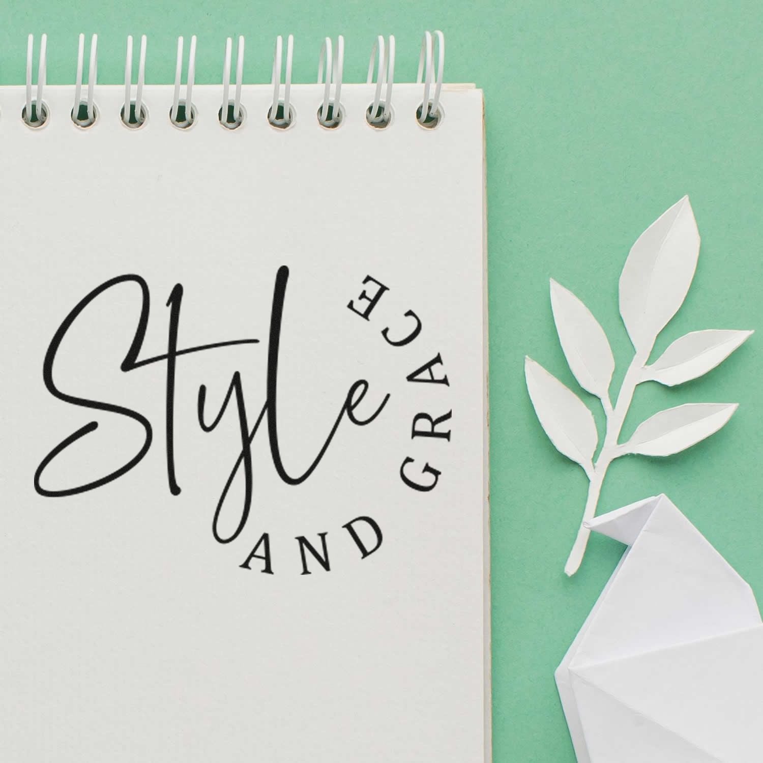 Style and Grace rubber stamp design on notebook, with paper leaves and envelope, for elegant crafting and journaling.
