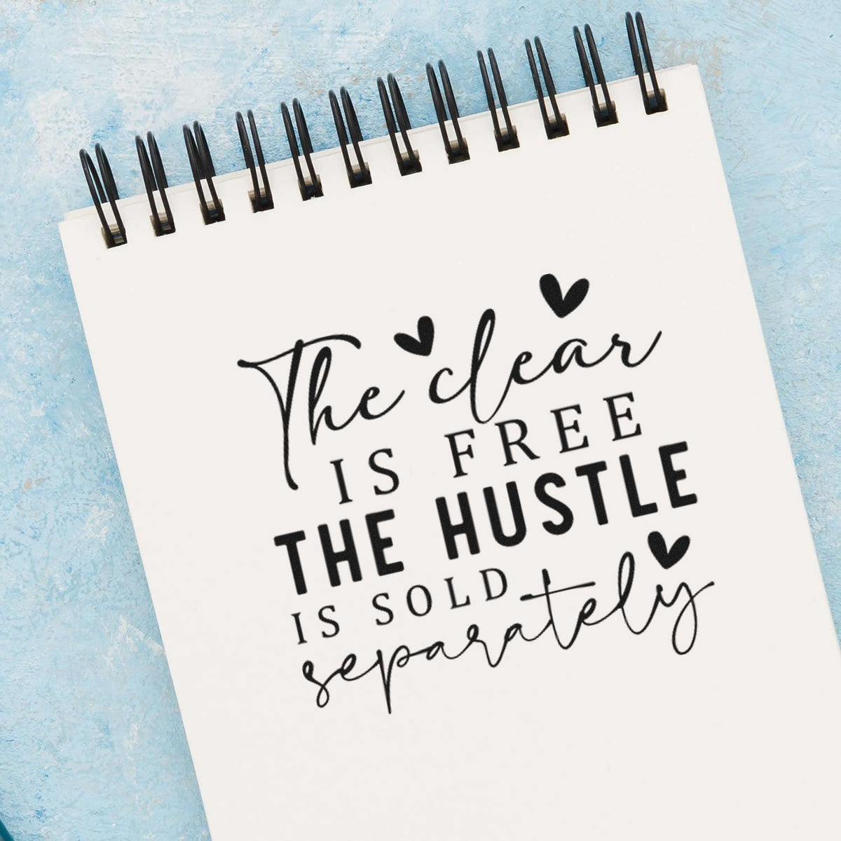 Hustle Sold Separately Heart Word Art PSI Pre-Inked Stamp imprint stamped in black ink. The visible phrase "The clear is free the hustle is sold separately" appears in mixed script and capitals with hearts.