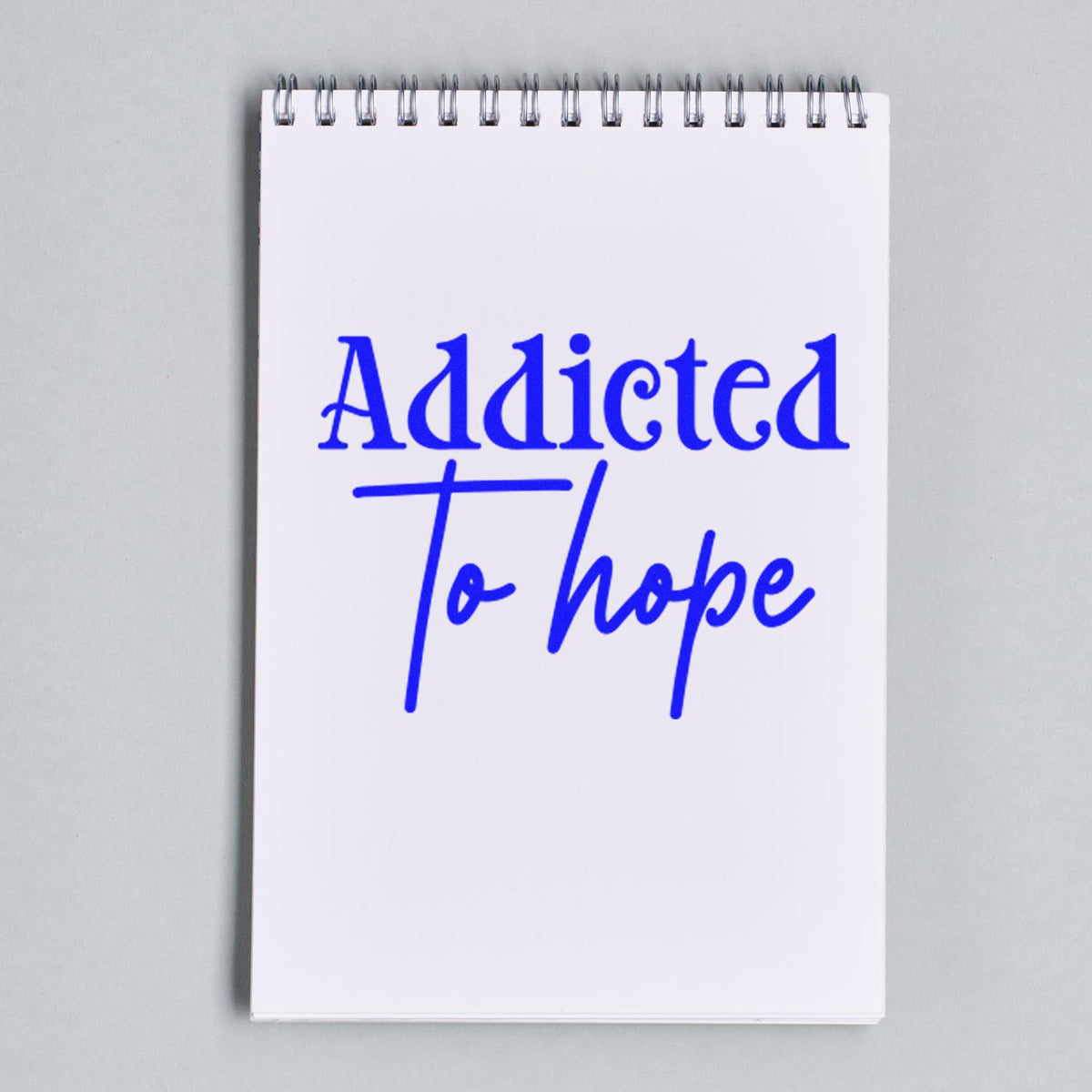 Addicted to Hope rubber stamp design in blue ink on a notebook page, ideal for motivational journaling and paper crafts.