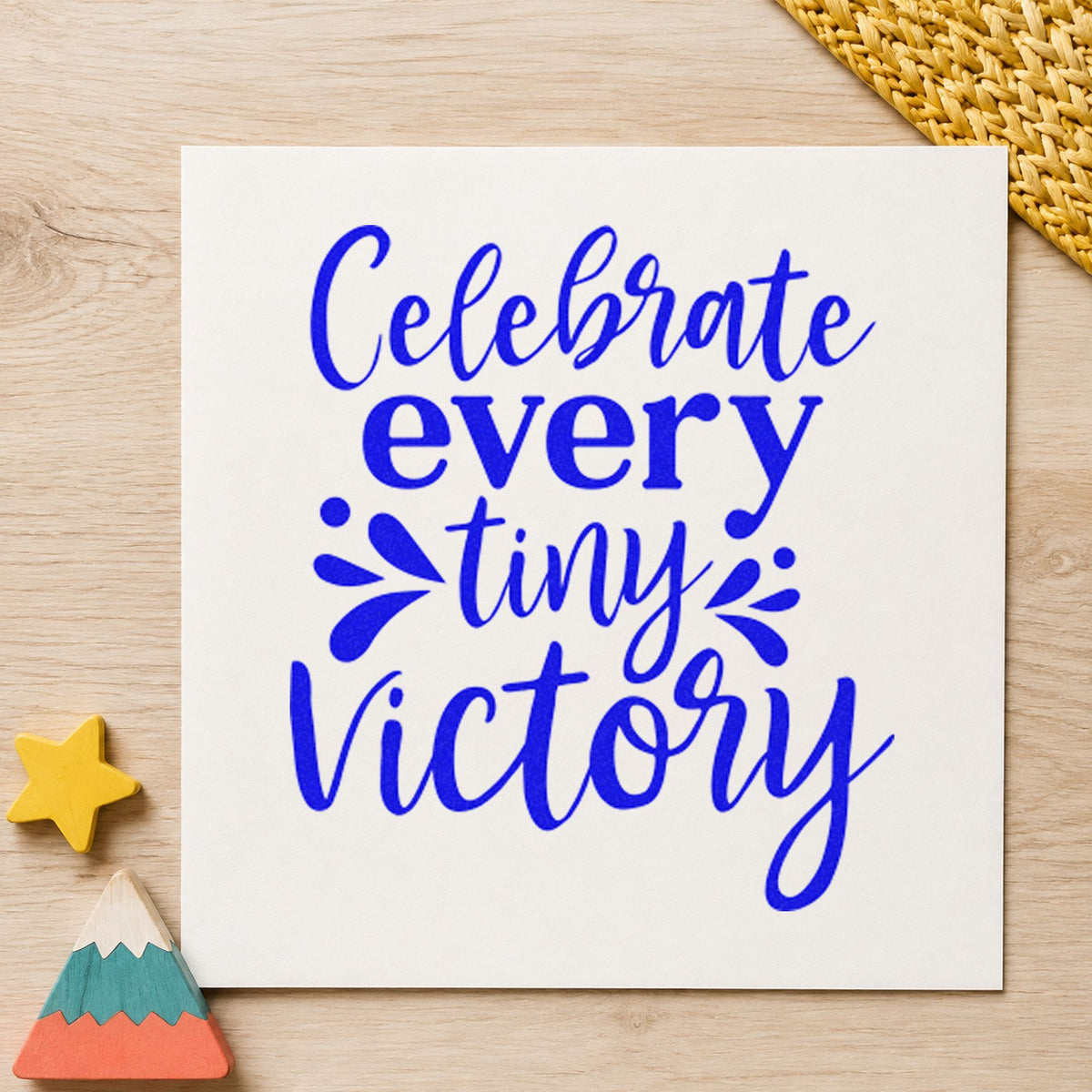 Celebrate Every Tiny Victory craft stamp imprinted in blue ink on paper, a design suited to framed linen closet.