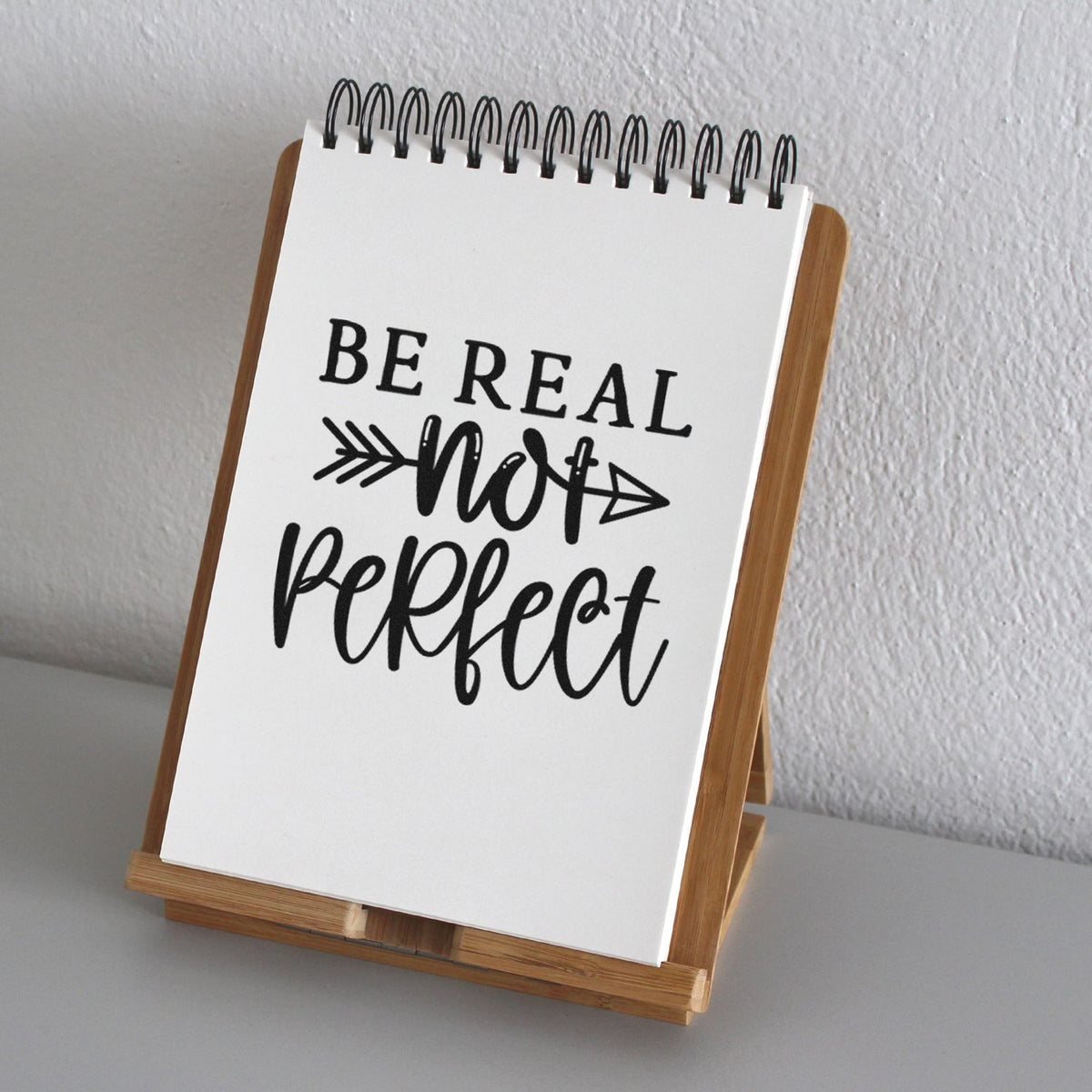 Be Real Not Perfect rubber stamp design on a notebook stand for inspirational journaling and craft projects.