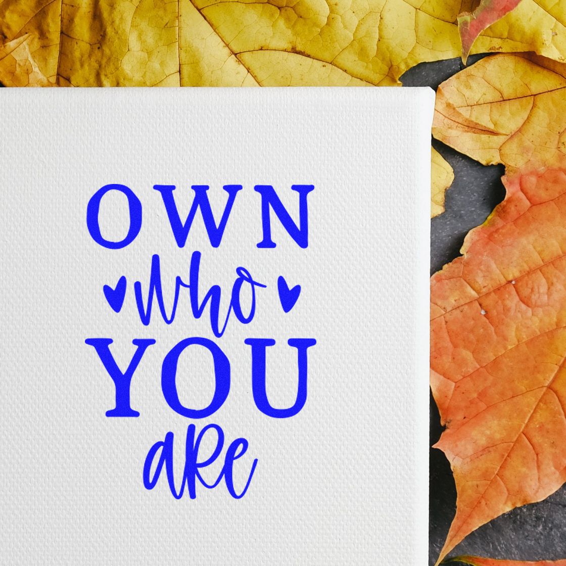 Inspirational rubber stamp design reading Own who you are in blue with hearts, ideal for handmade cards and fall crafts.