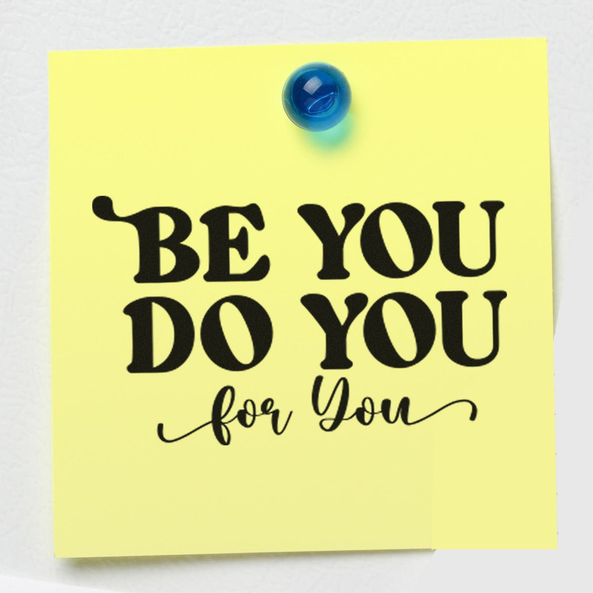 Inspirational rubber stamp imprint on yellow sticky note reading Be You, Do You, for You, pinned with a blue pushpin.