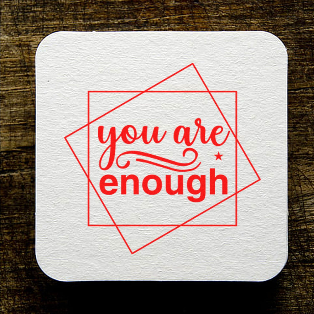 Motivational rubber stamp design with red you are enough message on a white square block.
