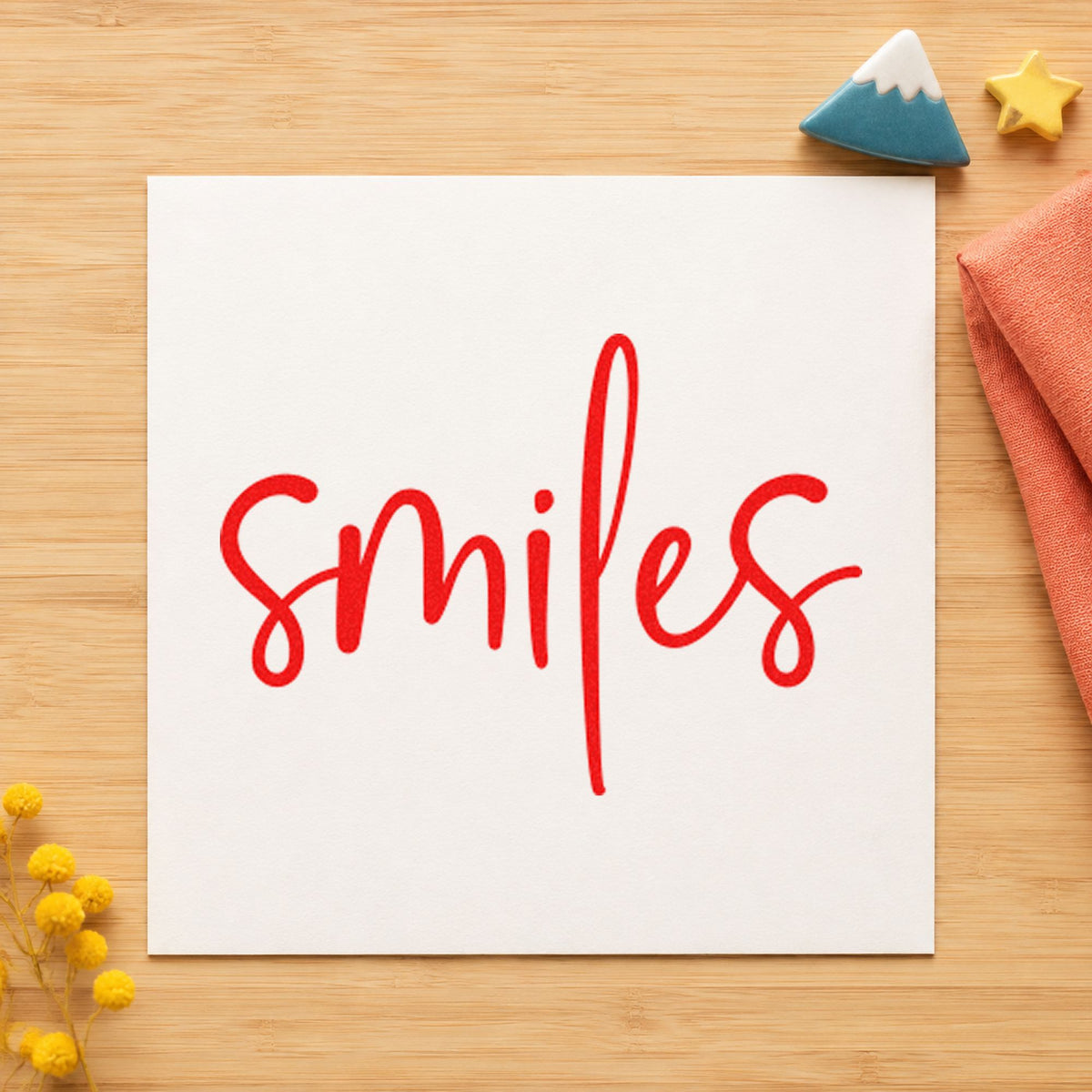 Smiles Simple Brush Script craft stamp imprint in red ink on a handmade project, one idea being guest book cards.