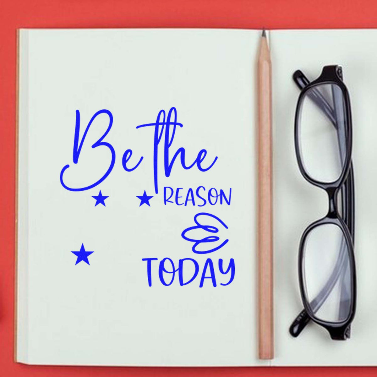 Motivational Be the Reason Today rubber stamp design in blue on a notebook, with stars, pencil and glasses.