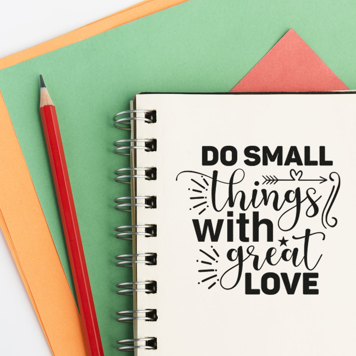 Rubber stamp quote reading Do small things with great love on spiral notebook, perfect for journaling and paper crafts.