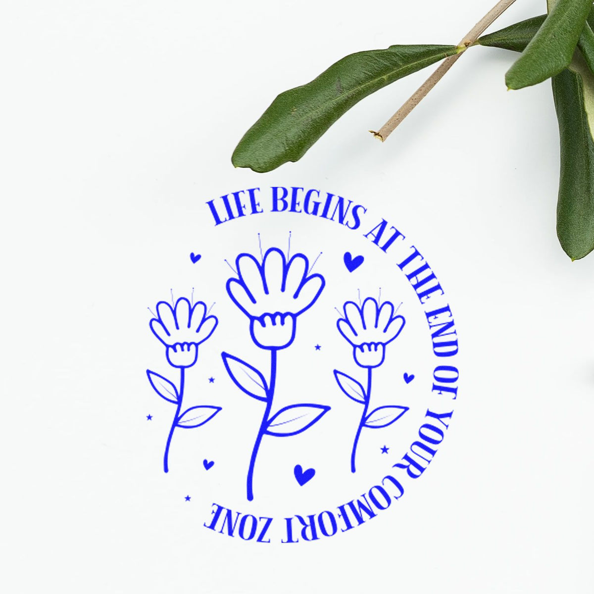 Blue rubber stamp design reading Life begins at the end of your comfort zone with floral line art and hearts.