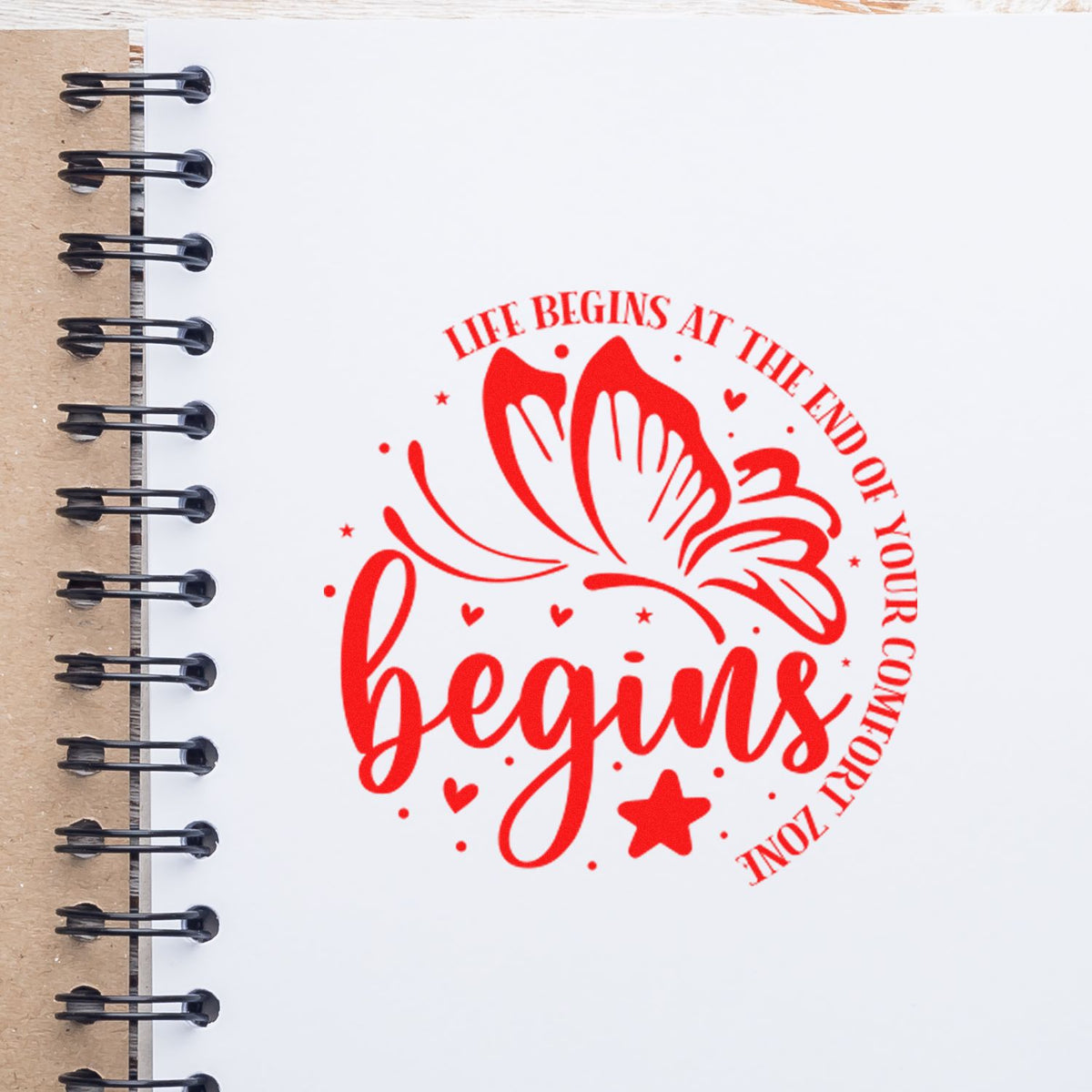 Red butterfly motivational rubber stamp with Life begins at the end of your comfort zone on notebook paper.