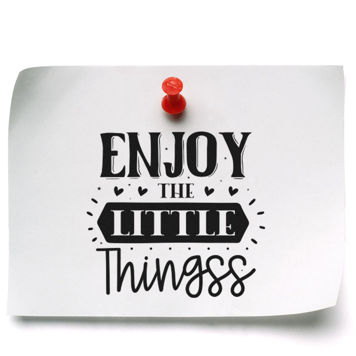 Decorative rubber stamp design reading Enjoy the Little Things in bold black lettering on white paper with a red pushpin.