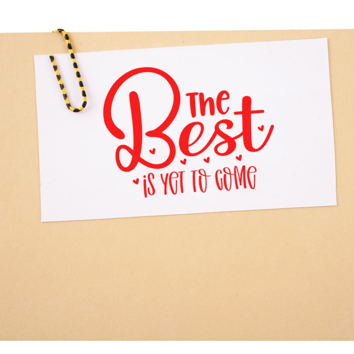 Rubber stamp design saying The Best Is Yet to Come in red script, ideal for cards, gifts, and motivational stationery.