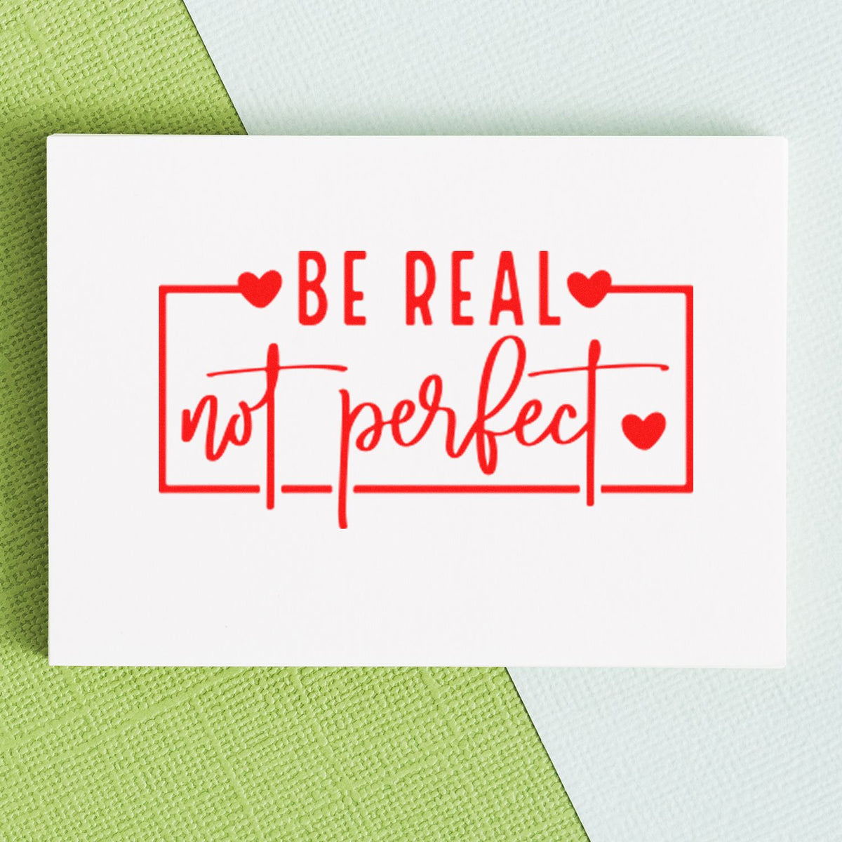 Be Real Not Perfect rubber stamp design with hearts in red ink on white card, ideal for inspirational craft projects.