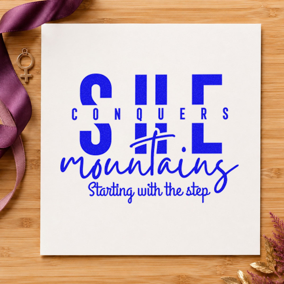 She Conquers Mountains Step craft stamp in blue ink on cardstock, an easy option for group buff printing.