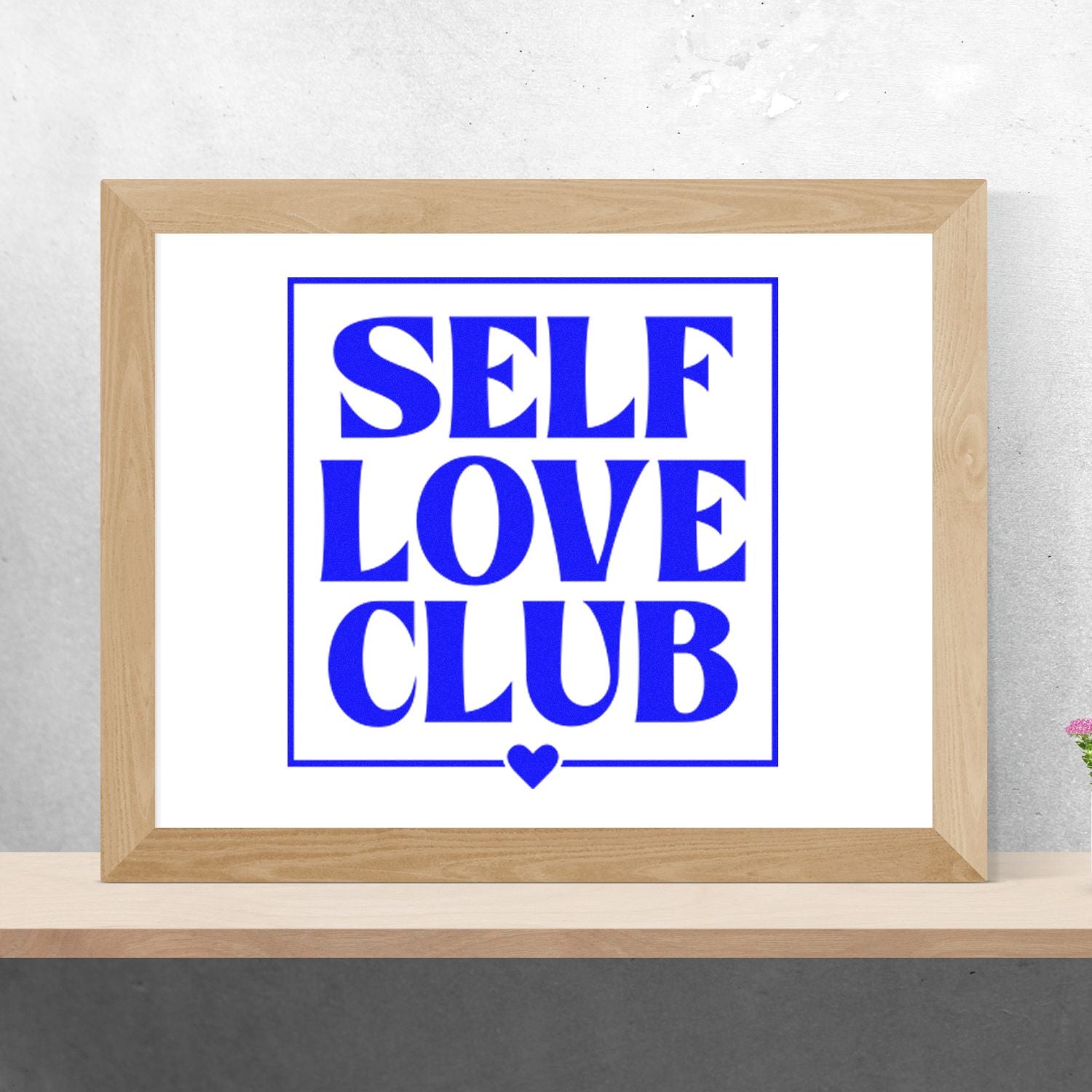 Self Love Club rubber stamp design preview with bold blue lettering and heart, shown in a framed mockup.