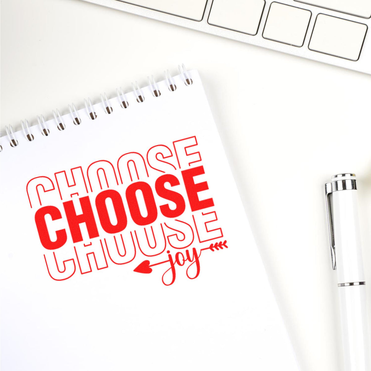 Custom rubber stamp design with red Choose Joy message on notebook, ideal for motivational office or craft projects.