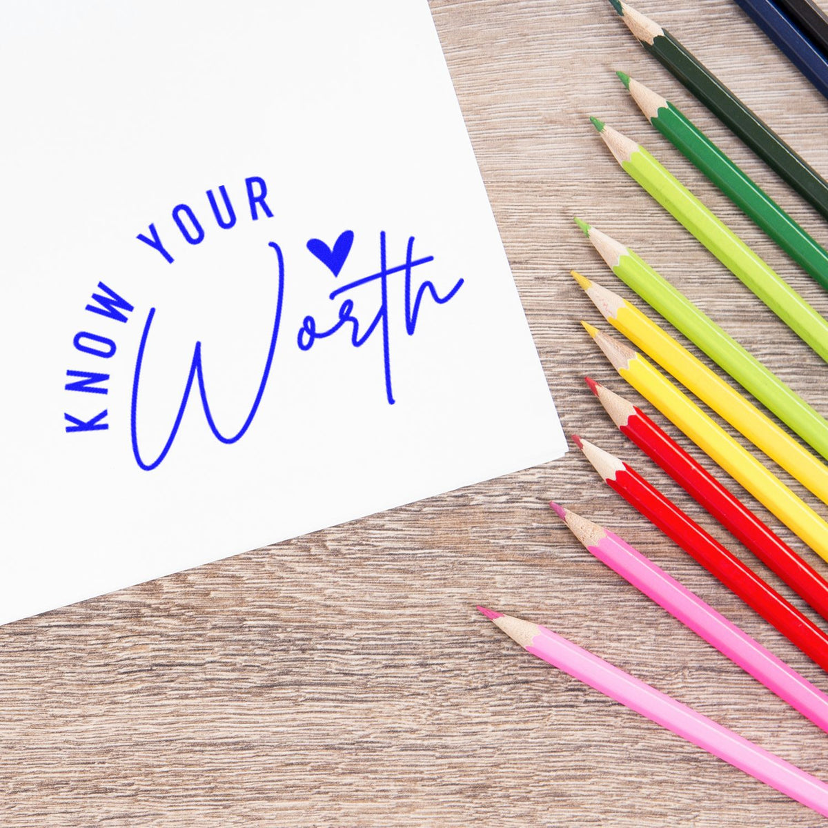 Know Your Worth rubber stamp impression on paper beside colorful pencils, ideal for motivational craft and stationery projects.