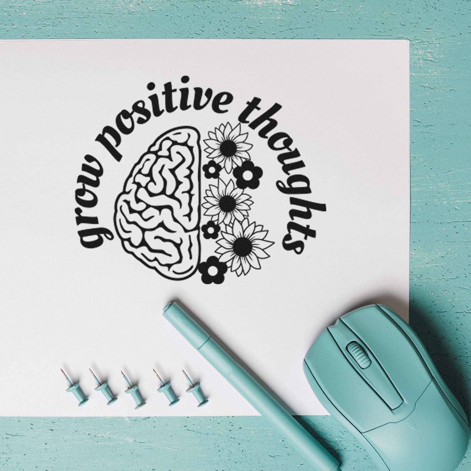 Custom rubber stamp design reading grow positive thoughts with brain and flowers, shown with mint stamp tool and accessories.