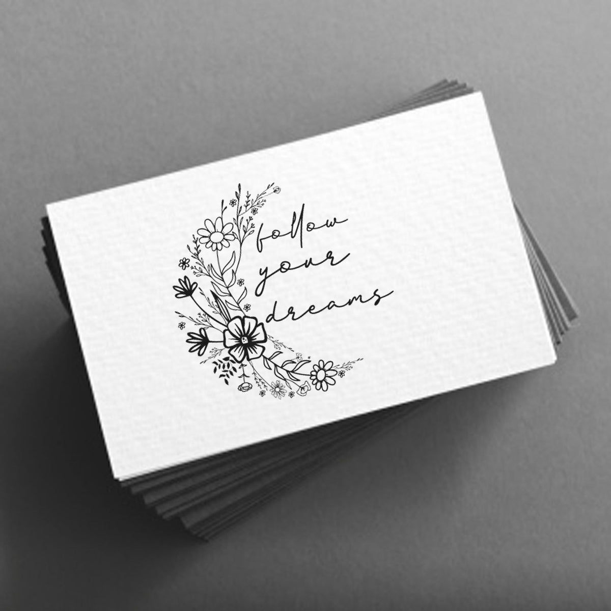 Floral rubber stamp design with follow your dreams handwritten quote on stacked business cards.