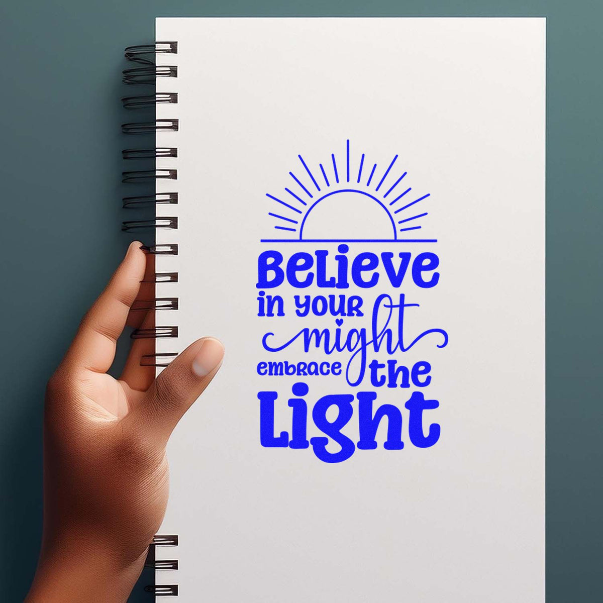 Motivational rubber stamp design with sunburst and quote, Believe in your might, embrace the light, on a notebook.