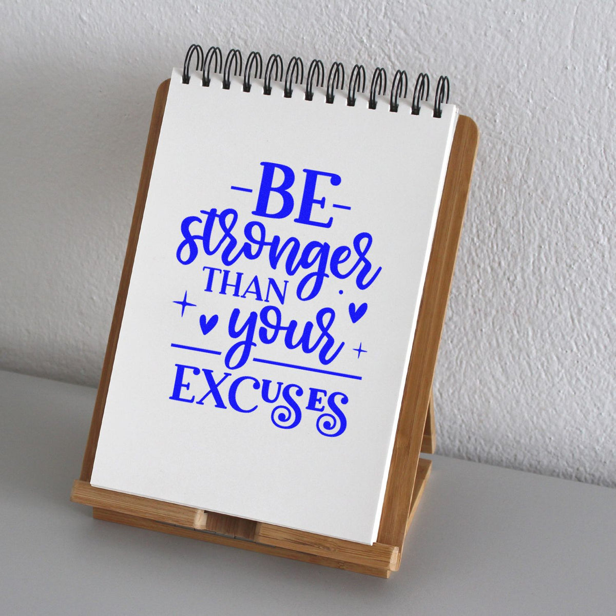 Motivational rubber stamp quote Be stronger than your excuses displayed on a notepad easel for crafting and office decor.