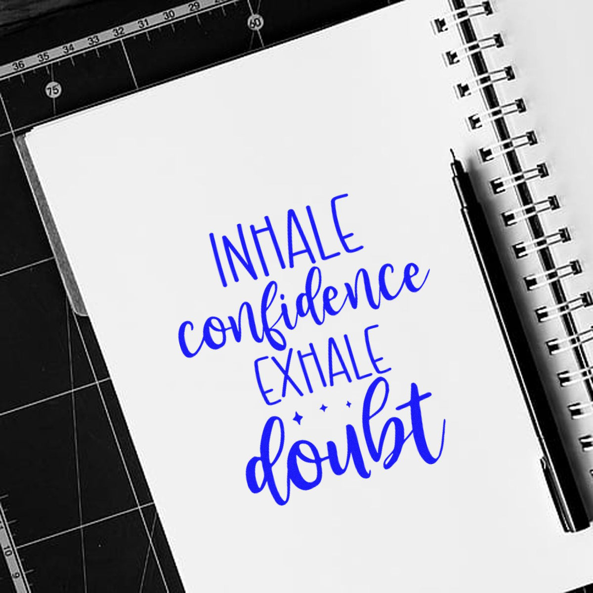 Inspirational rubber stamp quote Inhale confidence, exhale doubt on notebook, ideal for journaling and paper crafting.