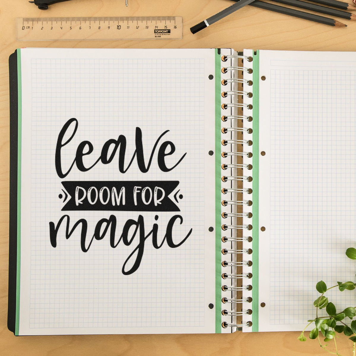 Rubber stamp design on graph notebook page reading leave room for magic with desk tools and pencils.