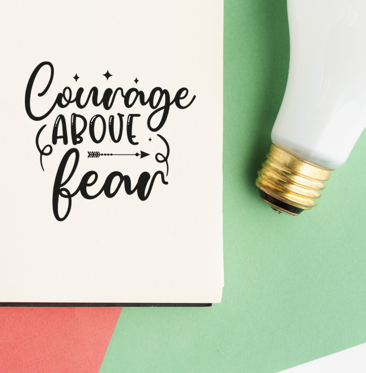 Courage Above Fear motivational rubber stamp impression with decorative lettering beside a light bulb design.