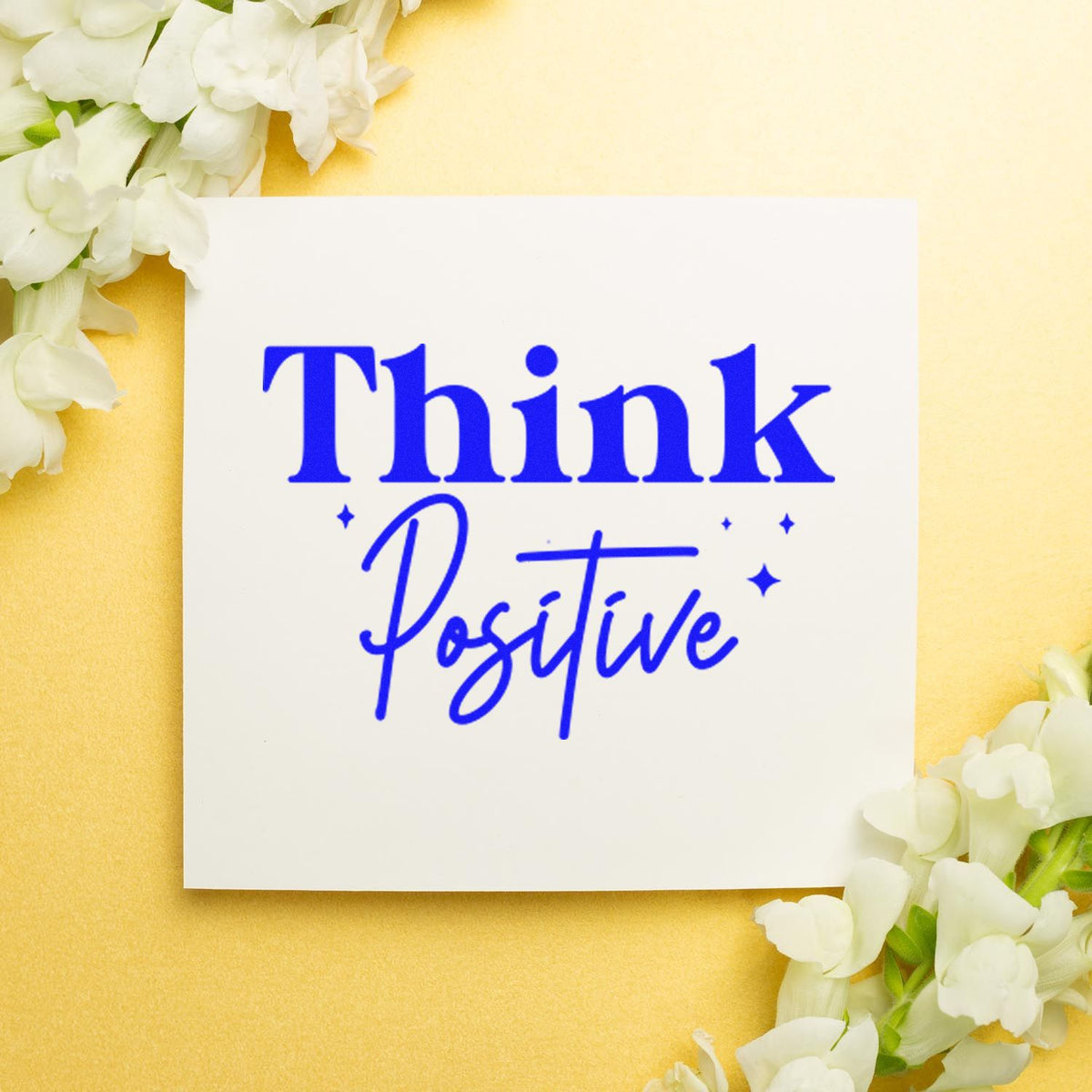 Think Positive rubber stamp with blue lettering and floral accents, perfect for uplifting handmade cards and crafts.