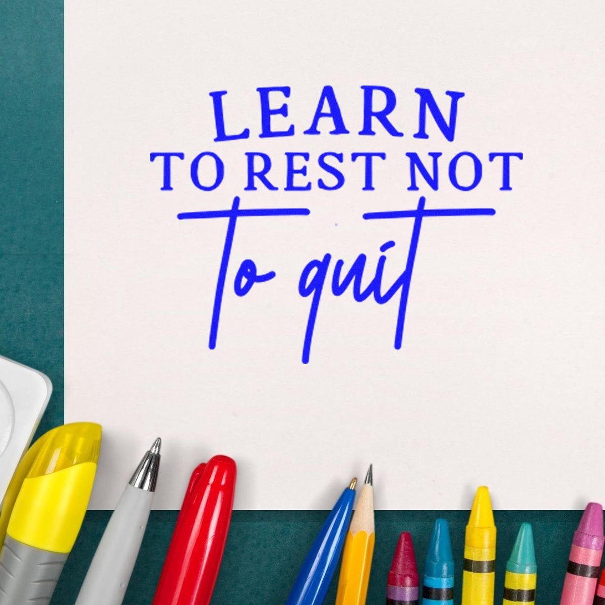 Motivational rubber stamp quote reading Learn to rest not to quit in blue ink on paper with colorful pens.
