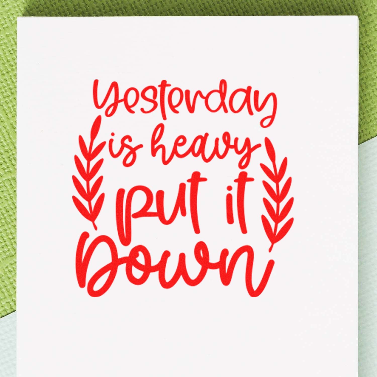 Red rubber stamp reading Yesterday is heavy, put it down with leafy accents, ideal for journaling, planners, and crafts.