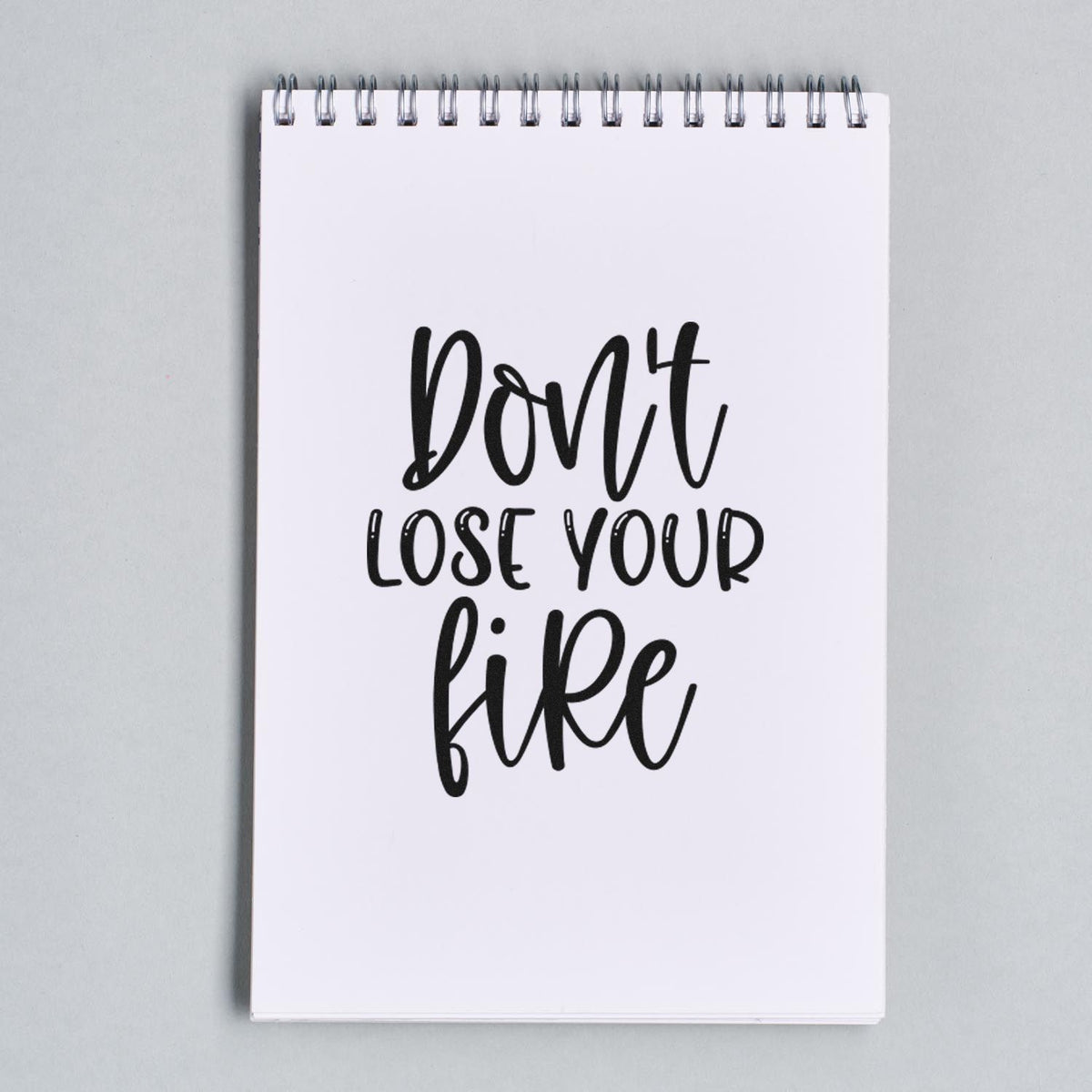 Dont lose your fire rubber stamp design in bold hand-lettered style on a spiral notebook.
