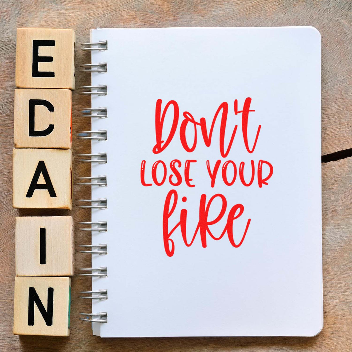 Wooden alphabet rubber stamps beside a notebook with a red Dont lose your quote design for craft lettering.