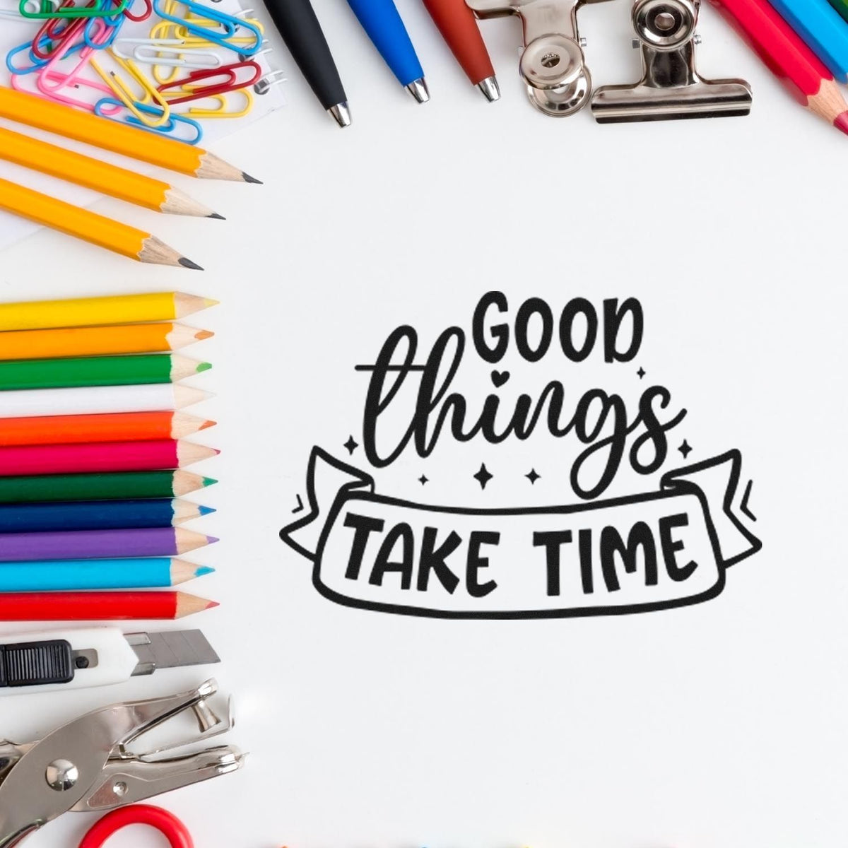 Good things take time rubber stamp design surrounded by colorful pencils, paper clips, and office supplies.