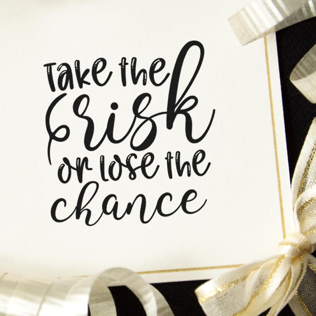 Motivational rubber stamp quote reading take the risk or lose the chance on a handmade card for crafts and scrapbooking.