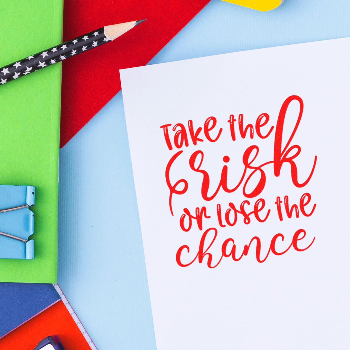 Motivational rubber stamp design with Take the risk or lose the chance quote for crafts, stationery, and DIY projects.