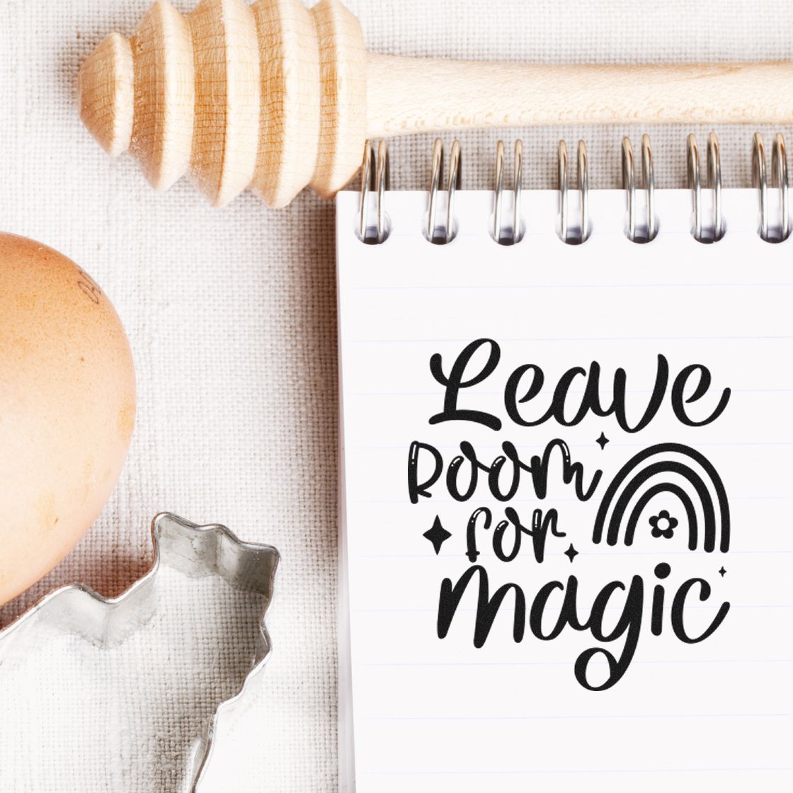 Inspirational rubber stamp design reading Leave room for magic on a notebook, styled with baking and craft props.