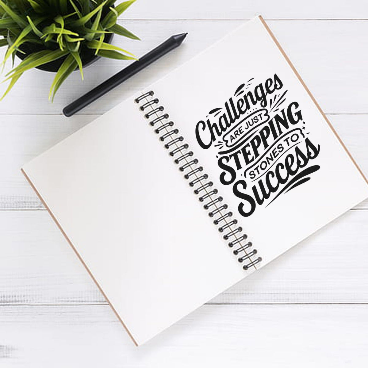 Motivational rubber stamp reading Challenges are just stepping stones to success on a notebook page.