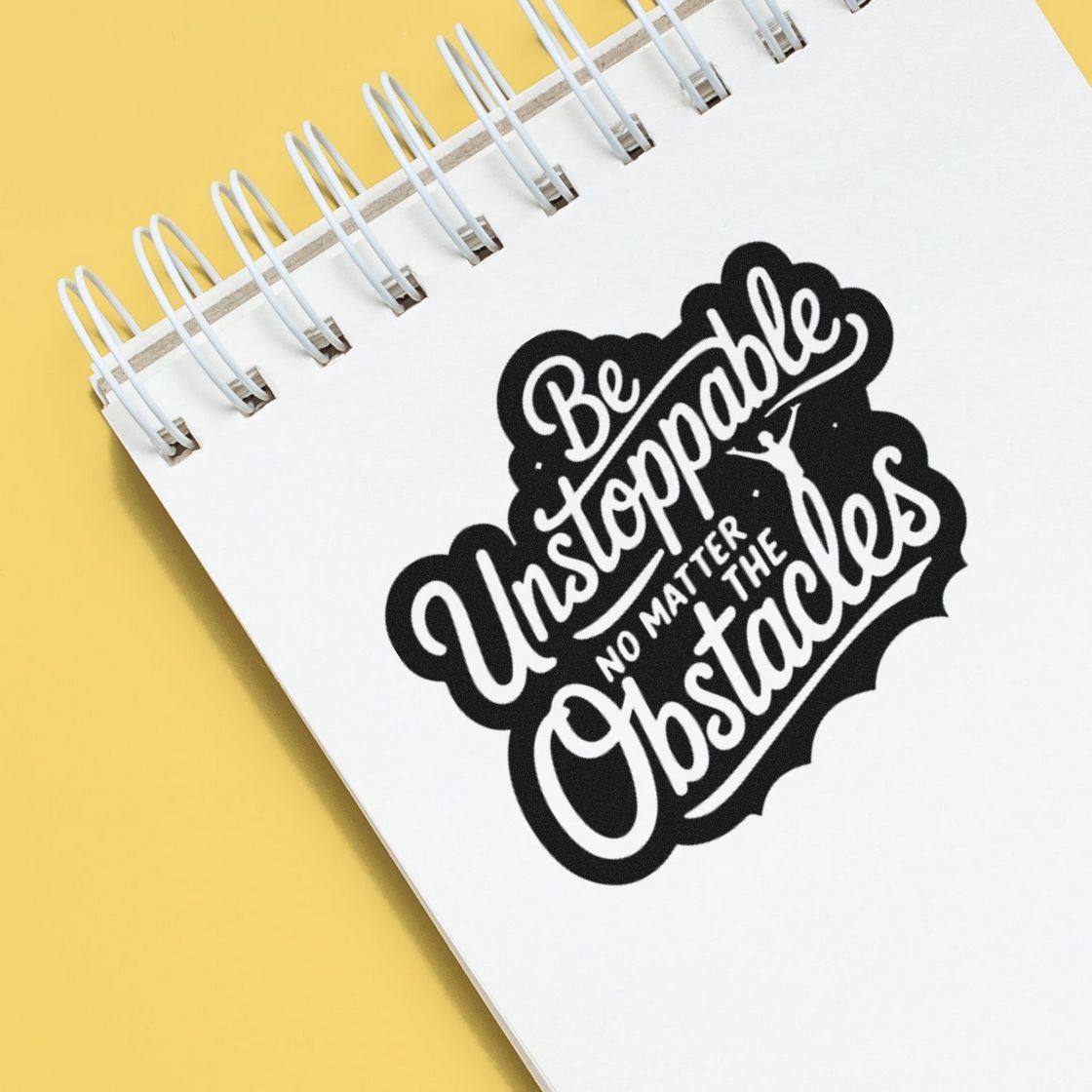 Custom rubber stamp design reading Be Unstoppable No Matter the Obstacles on a spiral notebook.