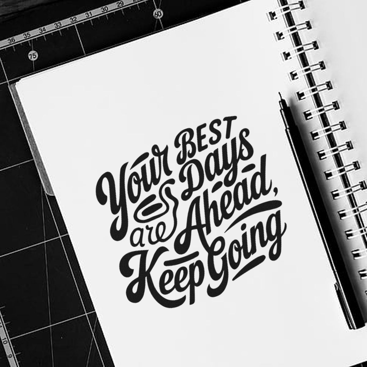 Custom rubber stamp with motivational quote, Your best days are ahead, keep going, on a notebook.