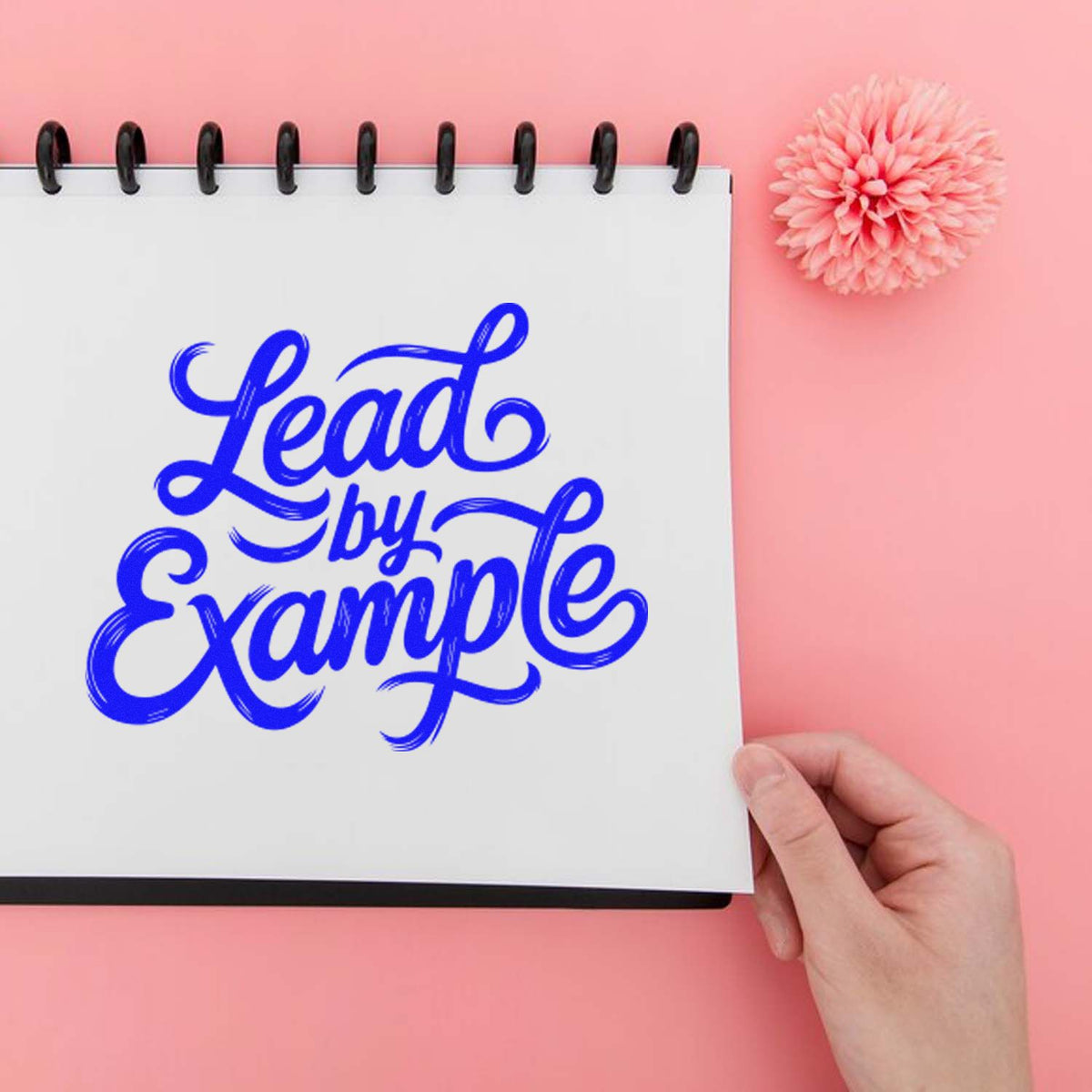 Lead by Example rubber stamp impression on notebook, ideal for custom motivational branding and office stationery.