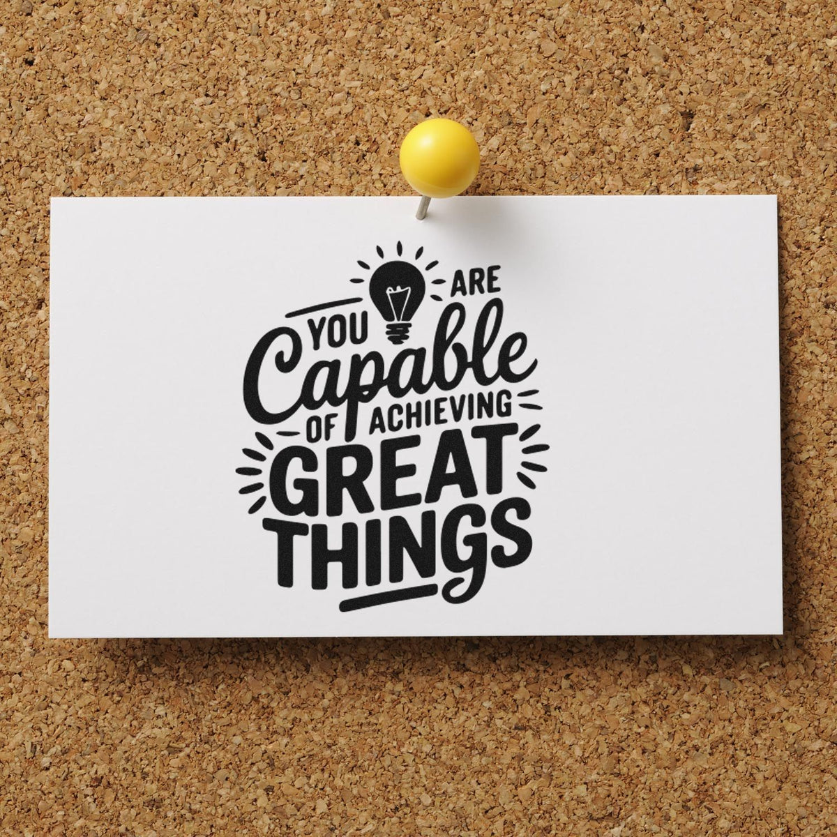 Motivational rubber stamp design with You Are Capable of Achieving Great Things pinned on a cork board.