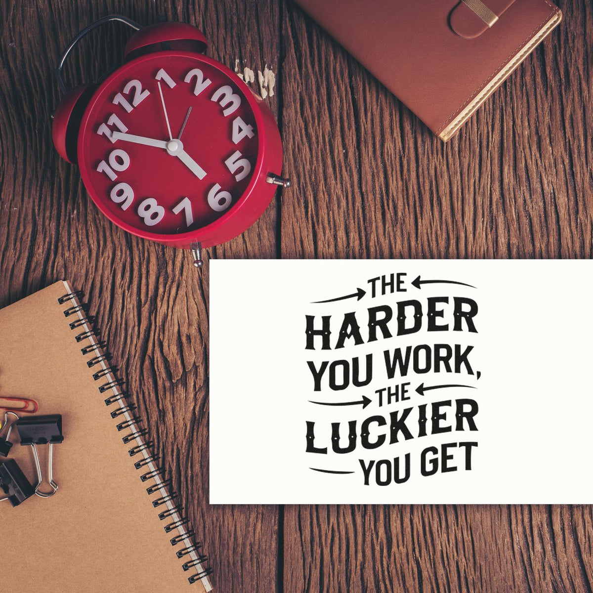 Custom rubber stamp with motivational quote, The harder you work, the luckier you get, on a desk flat lay.