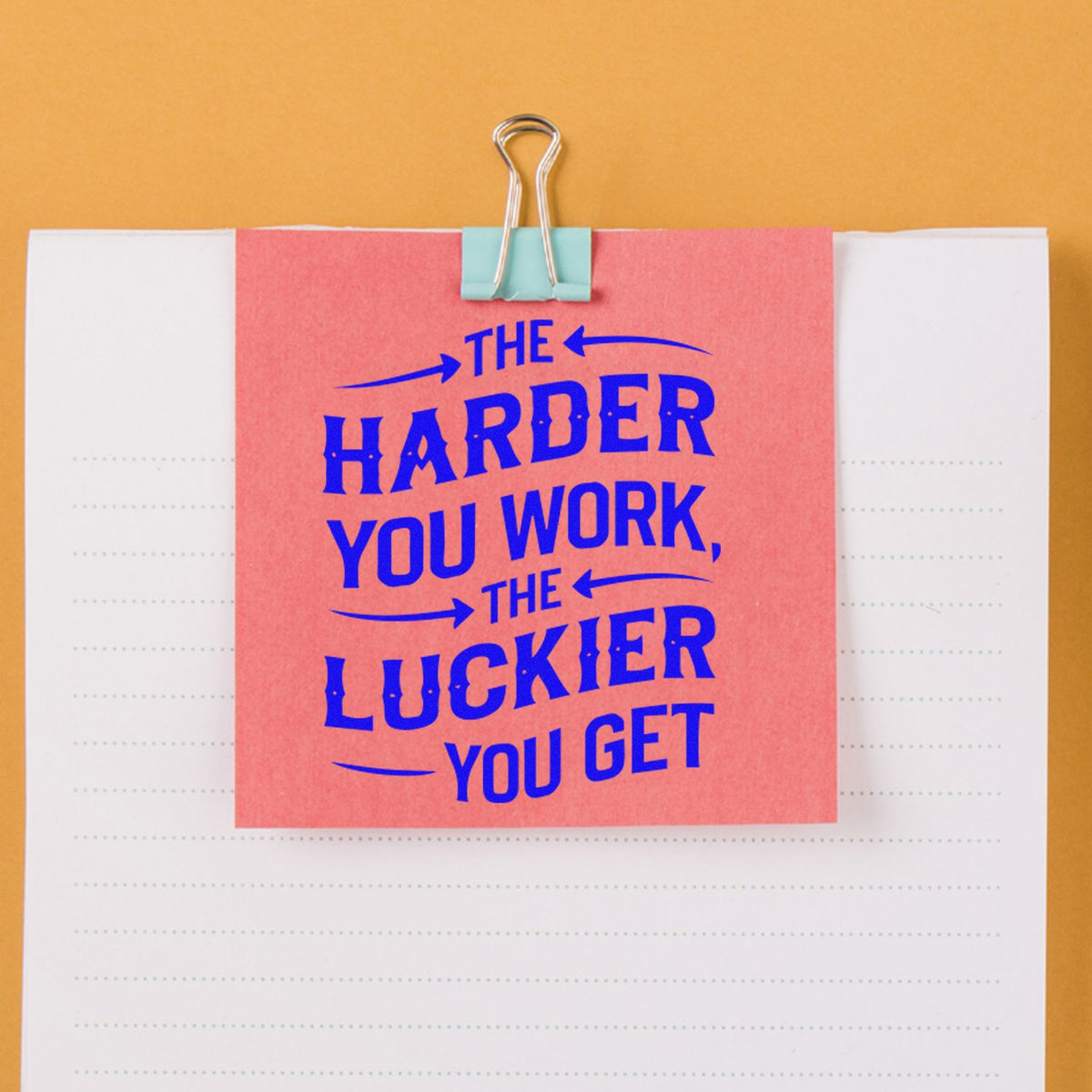 Inspirational rubber stamp design with quote The harder you work, the luckier you get on a clipped pink note.