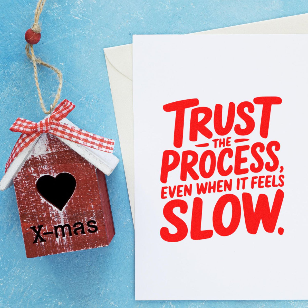Trust the process, even when it feels slow rubber stamp design on white card beside a handmade birdhouse ornament.