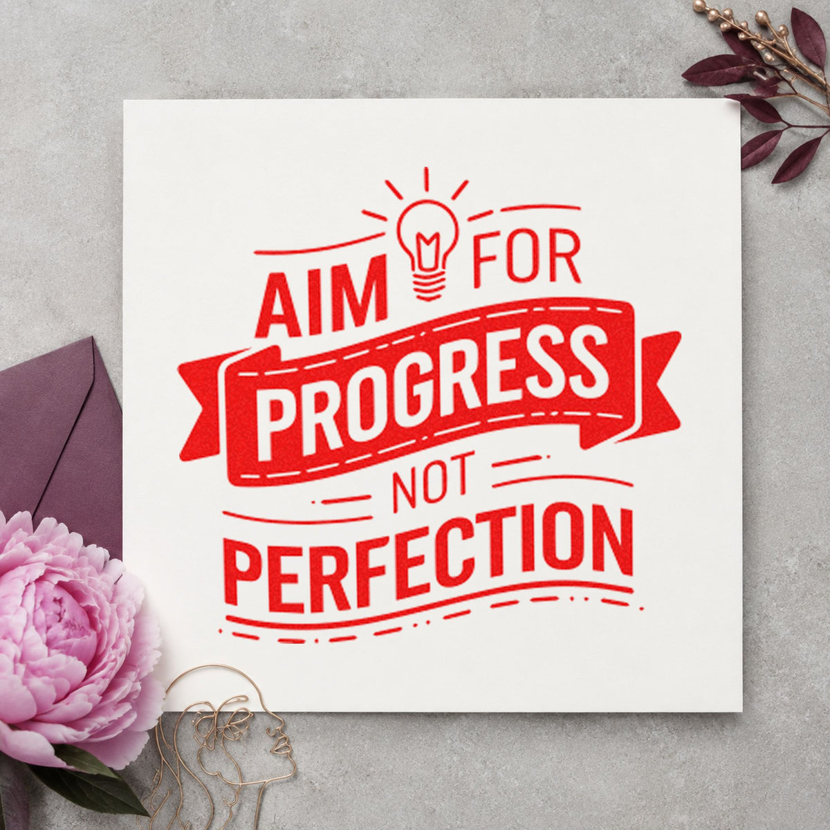 Aim Progress Not Perfection rubber stamp shown in red ink, stamped for projects such as bin paper labels.