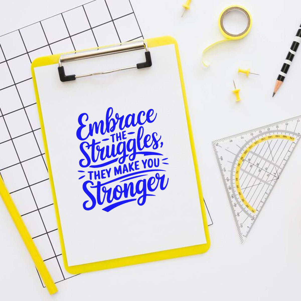 Motivational custom rubber stamp design on clipboard reading Embrace the Struggles, They Make You Stronger for school or office use.