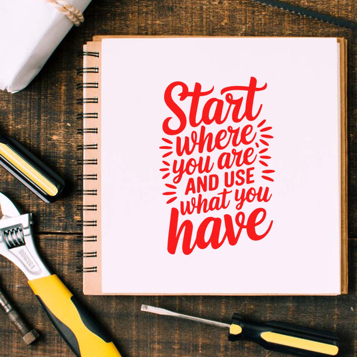 Rubber stamp quote design with Start where you are and use what you have on a notebook, styled with workshop tools.